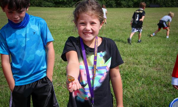 Girl holds out butterfly